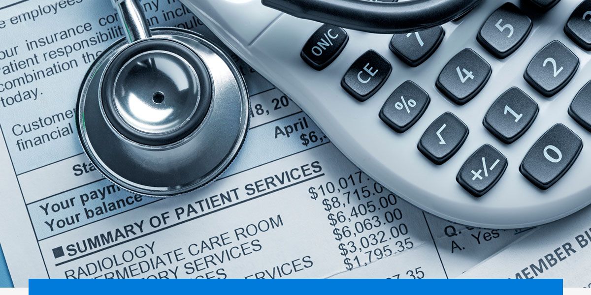 Calculator and stethoscope on top of a bill