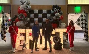 Phia in front of frost sign with race flag girls on sides